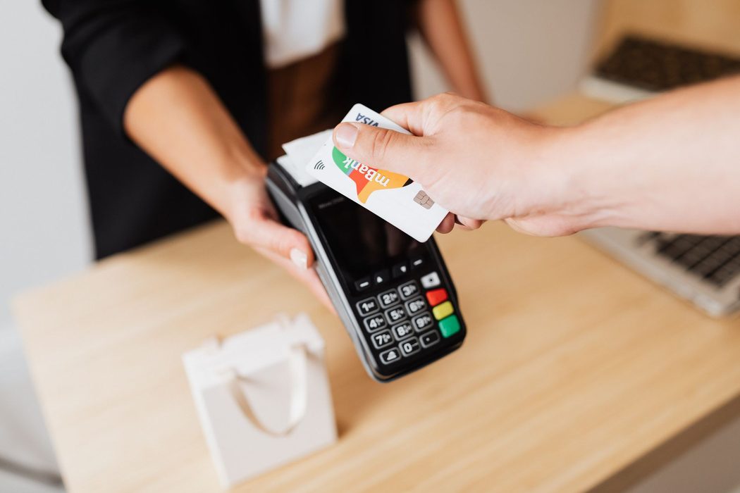 A payment terminal on a shop counter with a receipt printing